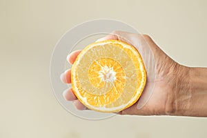 Woman`s hand Holding half of the lemon