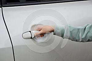 Woman`s hand holding the handle of the car