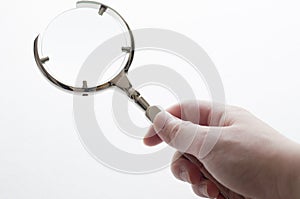 Woman's hand holding magnifying glass