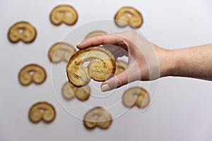 Woman`s hand holding a palmier cookie, palmerita traditional dessert photo