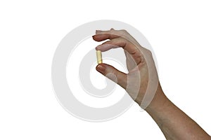 A woman`s hand holding a pill capsule, isolated photo