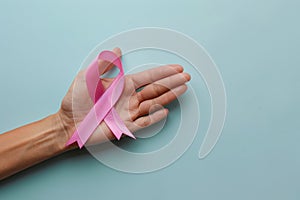 Woman's hand holding pink breast cancer awareness ribbon