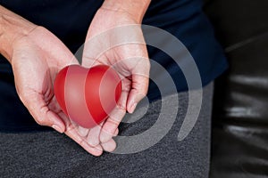 Woman`s hand holding red heart shape. Heart disease concept.