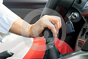 Woman's hand holding a the shift lever in a car