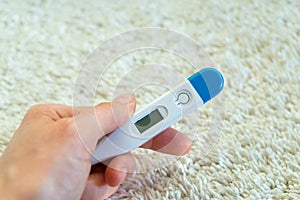 Woman`s hand holding the thermometer or the diagnostic test.