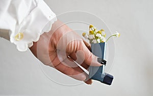A woman`s hand holds an asthma inhaler.