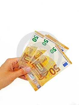 The woman`s hand holds the paper money of the euro against a white background.