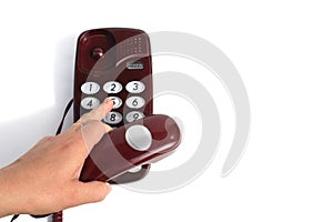 A woman`s hand holds a retro telephone receiver in her hand and presses the buttons to call the subscriber