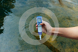 A woman`s hand holds a waterproof tester pen.