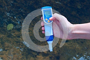 A woman`s hand holds a waterproof tester pen. People, science concept.