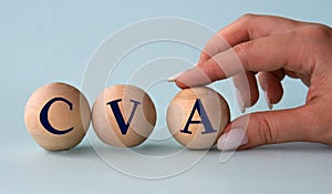 A woman's hand holds a wooden ball with the abbreviation CVA photo