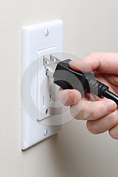 Woman's hand inserting an electrical plug photo