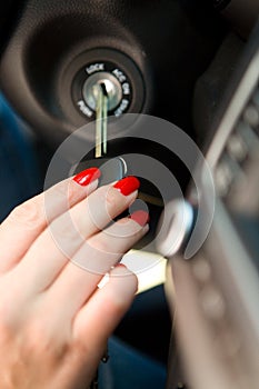 A woman`s hand inserts the ignition key into the lock.