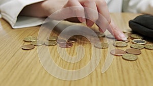 a woman\'s hand lays European coins on the table. Close-up. Rising prices. The impoverishment of people