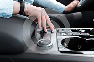 Woman`s hand lies on a car function settings wheel photo