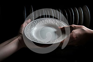 A woman's hand is loading dishes, emptying or unloading a dishwasher with dishes