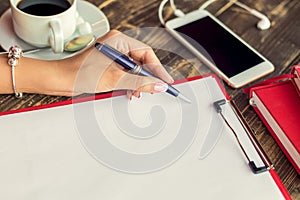 Woman`s hand making notes on paper