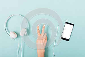 Woman's hand making victory gesture near headphones