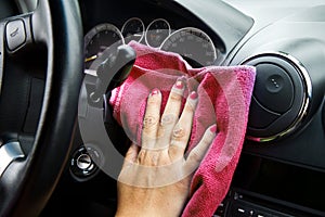 Woman's hand with microfiber cloth polishing of a car