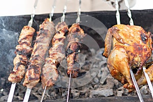 A woman`s hand in a mitten fries a barbecue on the grill in nature on a sunny winter day.