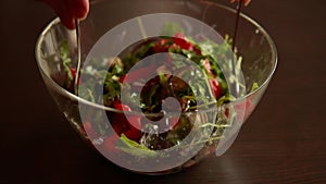 Woman\'s Hand Mixing Winter Salad with Rucola, Onion, Canned Red Peppers, and Walnuts