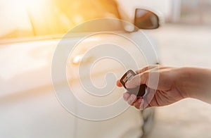 Woman`s hand open the car with car remote key