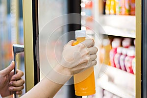 Woman`s hand open convenience store refrigerator shelves and pic