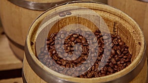Woman's hand opening the cover of wooden barrel full of fresh roasted coffee beans