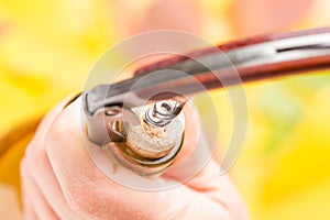 A woman`s hand opens a bottle of white wine with a corkscrew.. Top view.