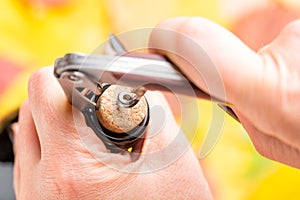 A woman`s hand opens a bottle of white wine with a corkscrew.. Top view.