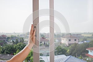 Woman`s hand opens the old sliding glass window.