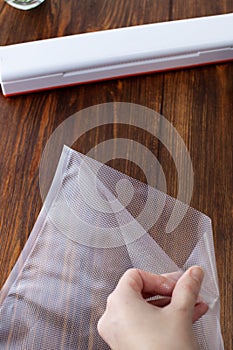 A woman`s hand opens a vacuum bag for packing products