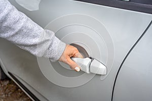 Woman`s hand opens white car door. Woman opens car door. Business woman opening car door, holding handle. Close up of hand female