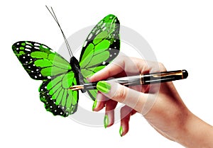Woman's hand is painting a vivid green butterfly
