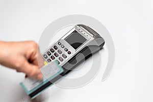 Woman`s hand passing credit card by a dataphone, card reader to charge in time of sales