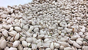 Woman`s hand picking California roasted pistachios at bulk foods section