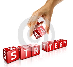 A woman`s hand places a cube to form the word strategy