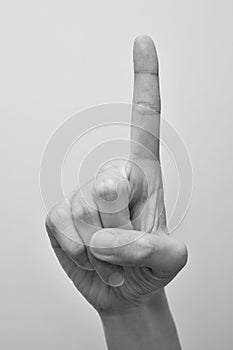 Woman`s hand pointing to something  on white background with black and white tone. Hand language concept. Communication