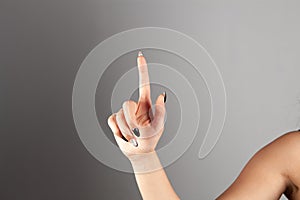 woman's hand points a finger up