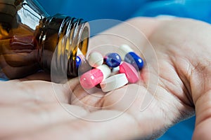 Woman`s hand pours the medicine pills