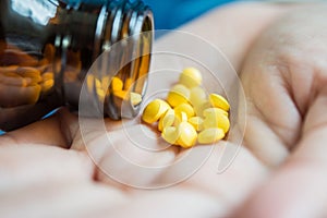 Woman`s hand pours the medicine pills
