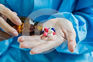 Woman`s hand pours the medicine pills