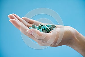 Woman`s hand pours the medicine pills