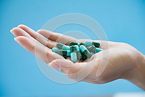 Woman`s hand pours the medicine pills
