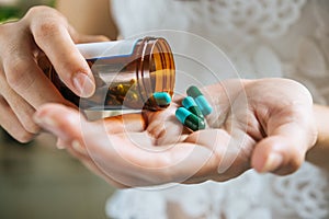 Woman`s hand pours the medicine pills out of the bottle