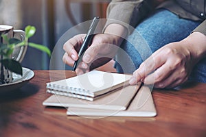 A woman`s hand preparing to write on blank notebook