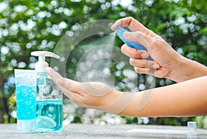 Woman’s hand pressing Alcohol Spray in the nature for clean her hand.