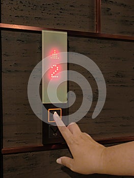 Woman`s hand pressing on up level elevator button