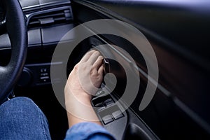 Woman\'s hand pushing a button to open a car door