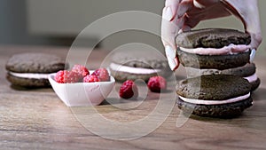 Woman's hand puts a chocolate chip cookie in a bowl